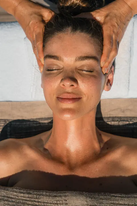 A guest, eyes closed, during a head massage