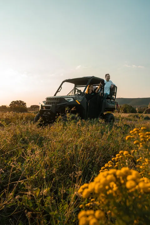 The off-road vehicle parked in the fynbos behind yellow flowers
