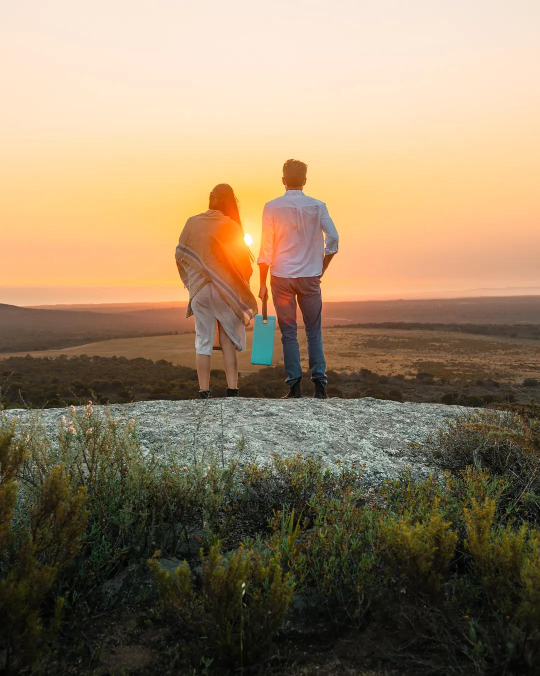 A couple stand on a rock at sunset, De Wildeveldt