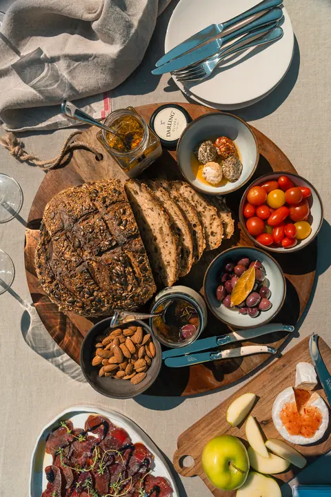 From above, a table of bread, small plates, fruit and nuts